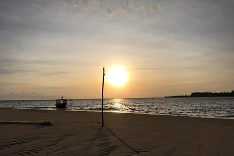 ZONSOPGANG FOTO bij EENZAAM STRAND waar RIVIER OCEAAN ONTMOET