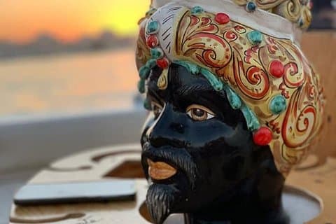 Siracusa: Aperitivo al atardecer en un barco, una isla y cuevas marinas