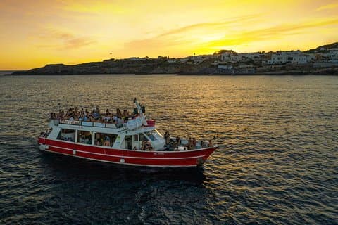 Bootsparty bei Sonnenuntergang in den Gewässern des Salento mit Getränk