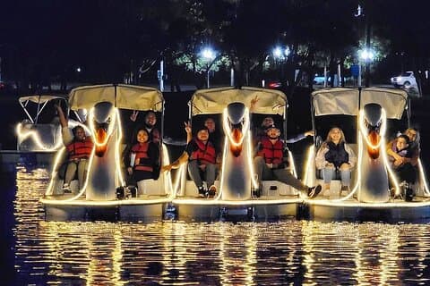 Upplyst Swan Boat nattritt på Rainbow Lagoon i Long Beach
