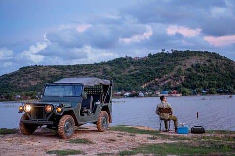 Landsbygd och solnedgång med militärjeep