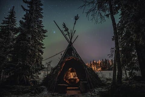 Arktisk sjö Aurora Hunt, i en mysig lappisk tipi