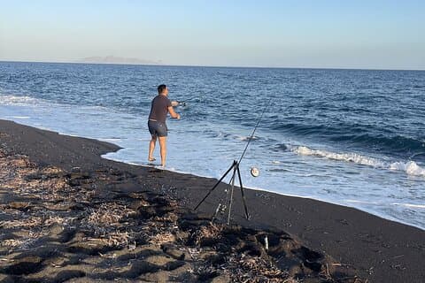 Santorini Pesca en una playa volcánica tranquila