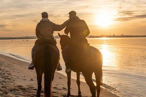 Paseo privado a caballo al atardecer en la playa
