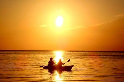 SUP- of kanotocht bij zonsondergang op Miyakojima in Okinawa